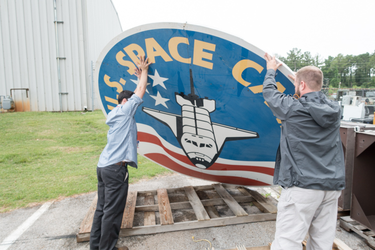 Two people holding the ten foot Space Camp sign